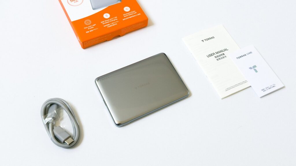 開封中のMiniMag Pro一式。グレーのUSB-Cケーブル、シルバーの本体、TORRAS取説と保証カードが整然と並んでいる。