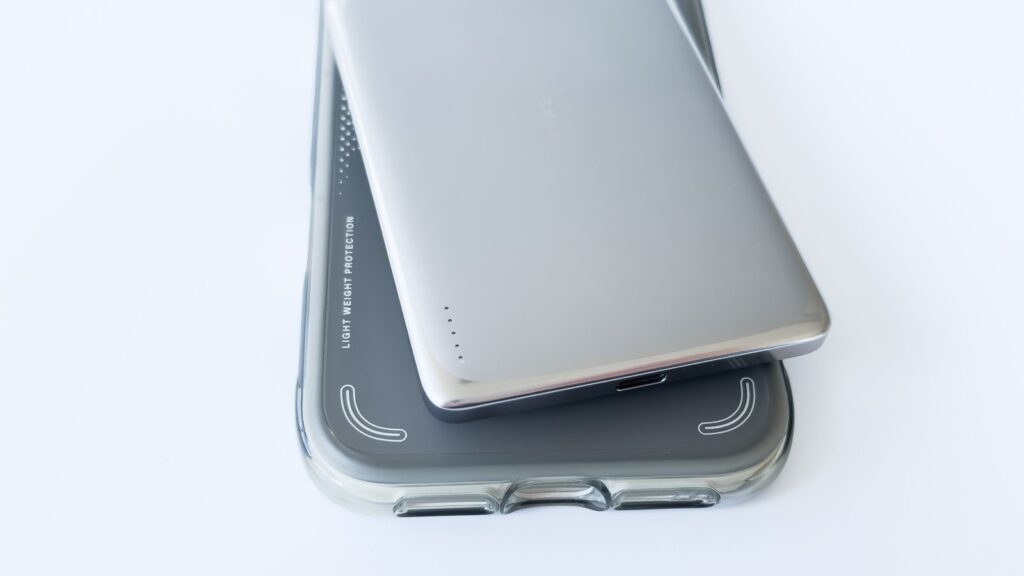 TORRAS Ostand Q3 Air ケース(LIGHT WEIGHT PROTECTION刻印)の上にMiniMag Pro を重ねた構図。両製品の表面仕上げの違いが横並びで分かる。
