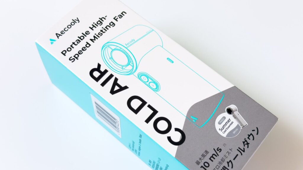 水色と白のCOLD AIRパッケージを斜め上から接写したもので、Portable High-Speed Misting Fanの英字、本体線画、白い実物写真の入った丸ラベル、10m/sの表記が読み取れる。
