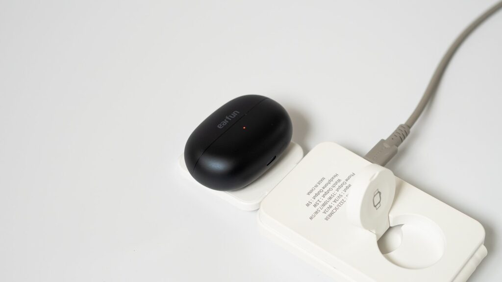ワイヤレス充電パッドにケースを載せたカット。赤いランプが点灯し充電中であることを示す。