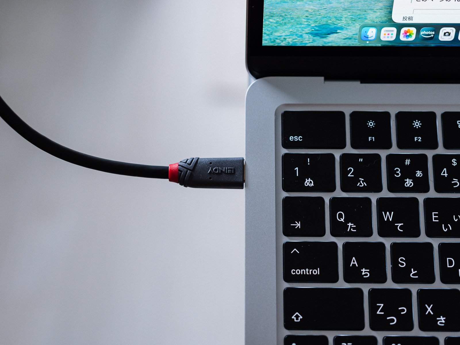 MacBookのUSB-Cポートに接続したLINDY製ケーブル。コネクタ根元は赤いアクセントで、側面にブランド名が刻印されている。
