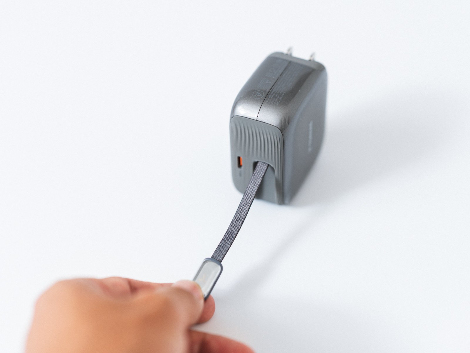 TORRAS FlexLine Pro 60Wから内蔵USB-Cケーブルを手前へ引き出している状態。編み込み被覆のケーブルと端子が確認できる。
