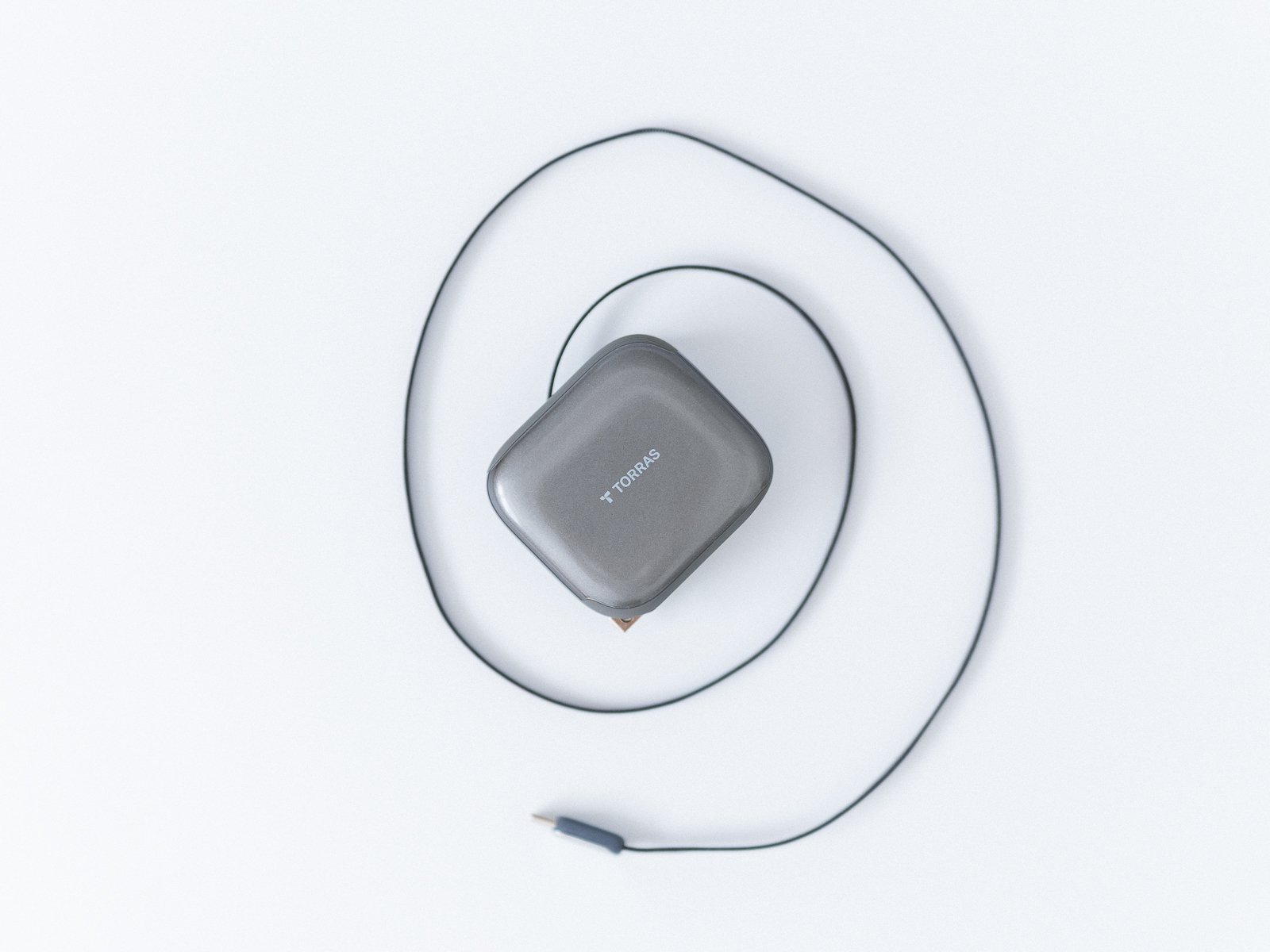 TORRAS FlexLine Pro 60Wの内蔵USB-Cケーブルを白い背景上で大きく伸ばした状態。本体を中心にケーブルが円を描くように配置されている。