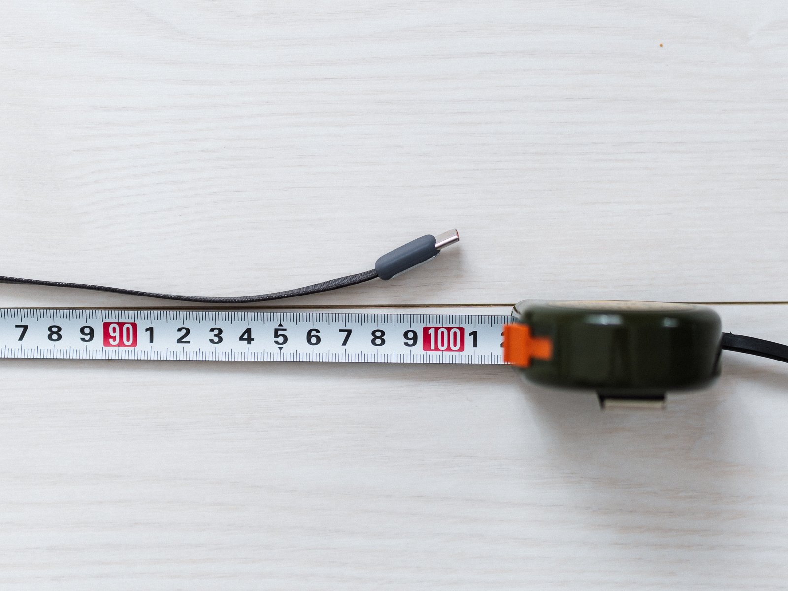 TORRAS FlexLine Pro 60Wの内蔵ケーブル先端をメジャーの100センチ付近に置いた状態。USB-C端子と長さの目盛りが確認できる。