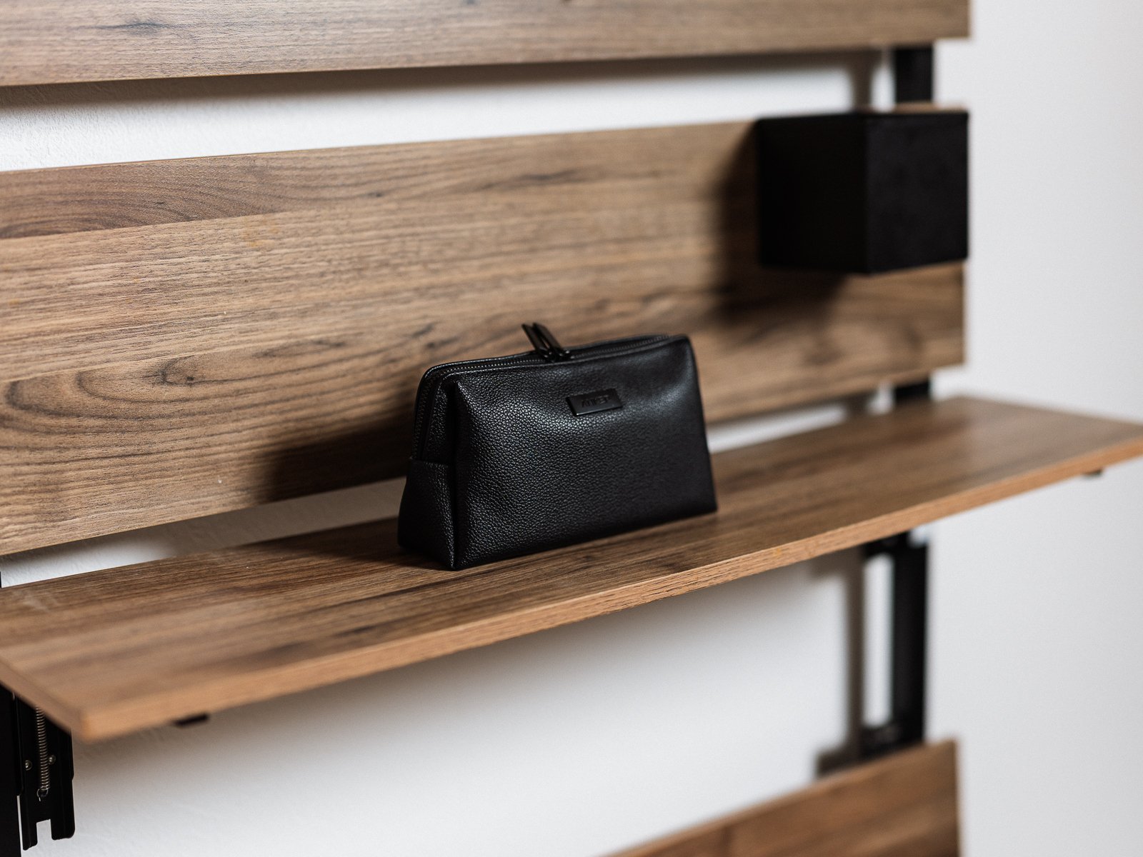 木製シェルフに自立させた黒いAnker Style Pouch。前面のAnkerロゴと、形を保ったまま置ける本体形状が確認できる。