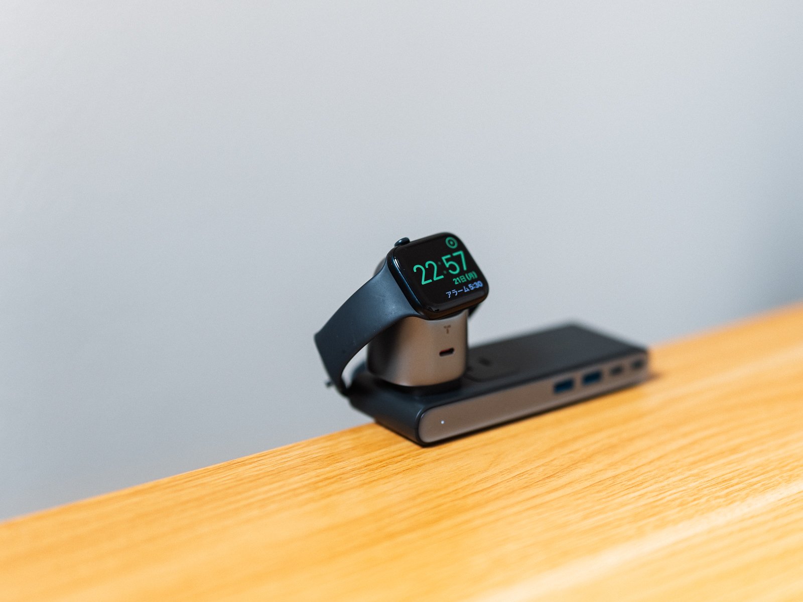 TORRAS Flasheyeの充電面にApple Watchを載せた状態。電源タップに接続し、時計の画面を見やすい角度で充電している。