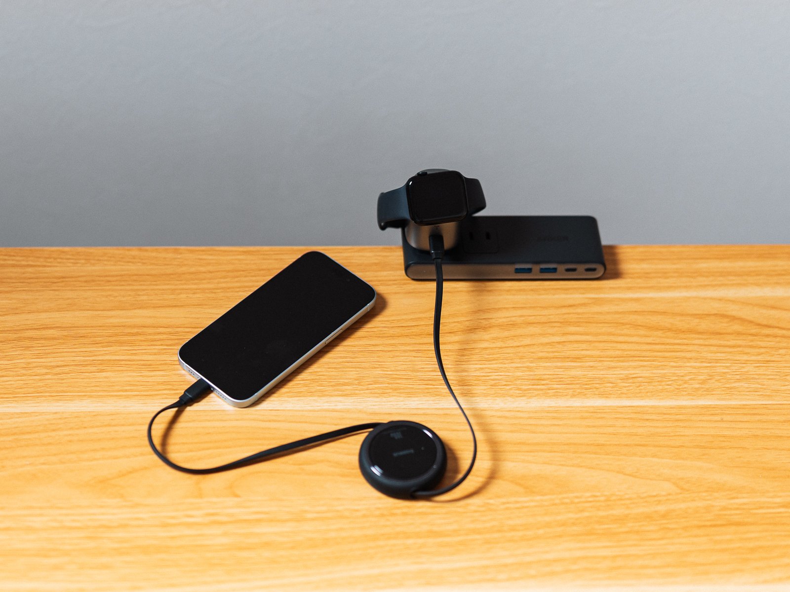 TORRAS FlasheyeでApple WatchとiPhoneを同時充電している状態。USB-Cケーブルが円形の巻き取り機構を通ってiPhoneにつながる。