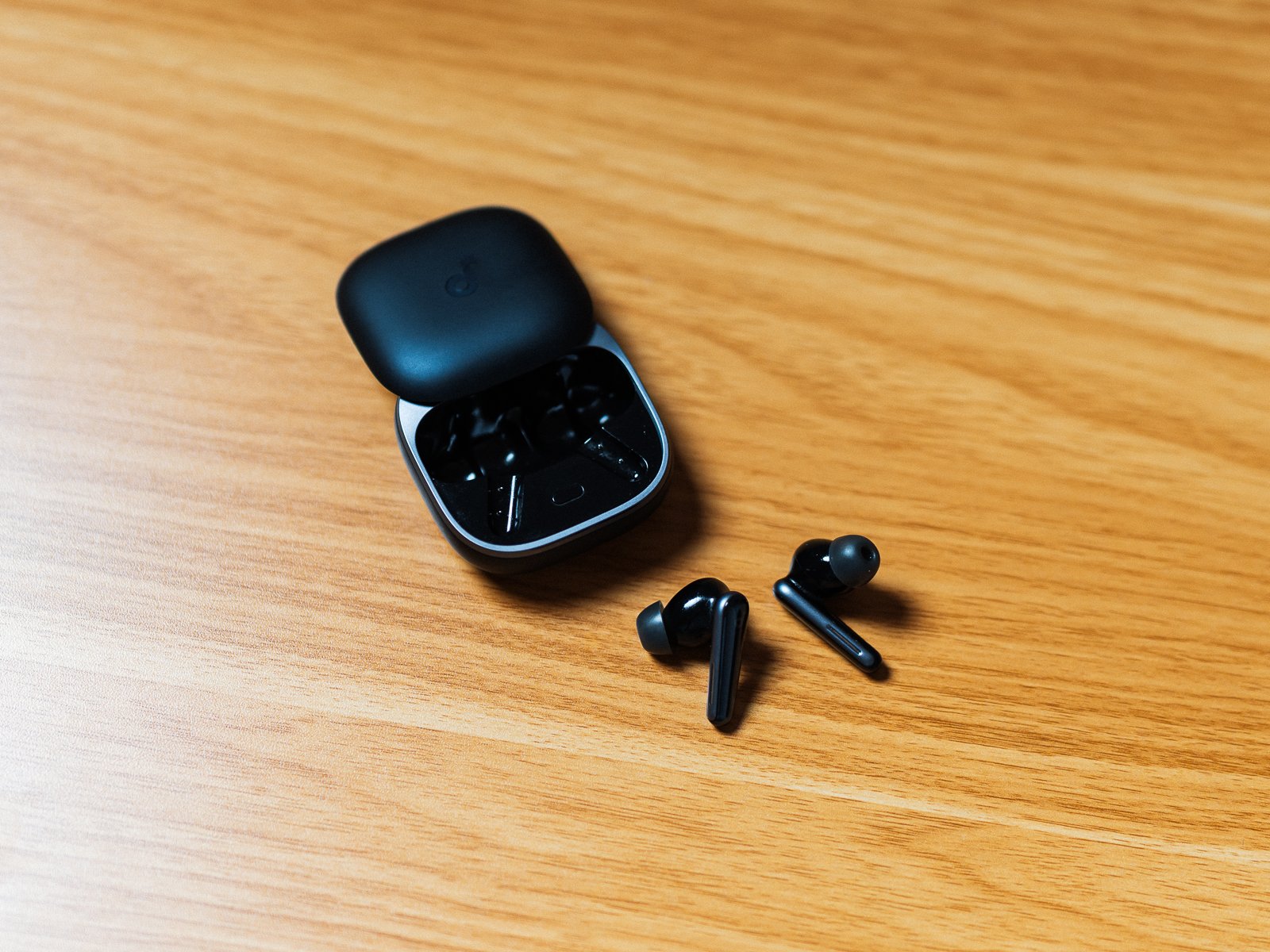 Soundcore Liberty 5の充電ケースを開き、左右のイヤホンを手前に置いた状態。ケース内部の収納位置とイヤホン形状が確認できる。