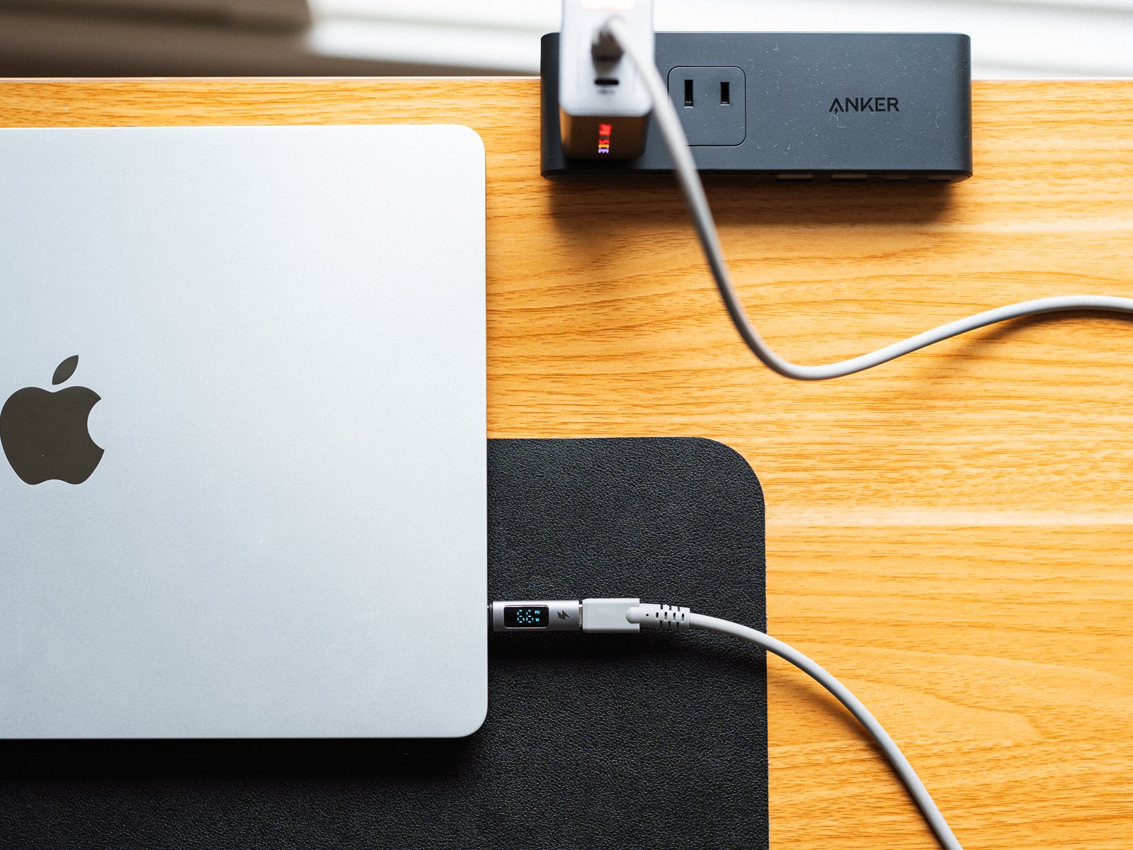 PHYSCE 67W GaN急速充電器でMacBook Airを1台だけ充電している様子。本体のライトは赤く光り、ケーブルの表示部にワット数が出ている。